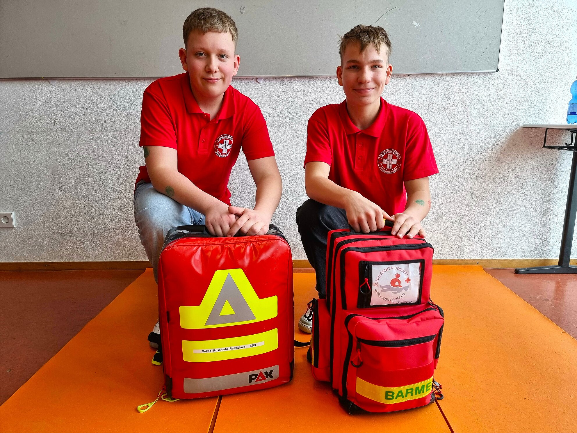 Zwei Schulsanitäter mit ihren beiden Sanitätsrucksäcken.