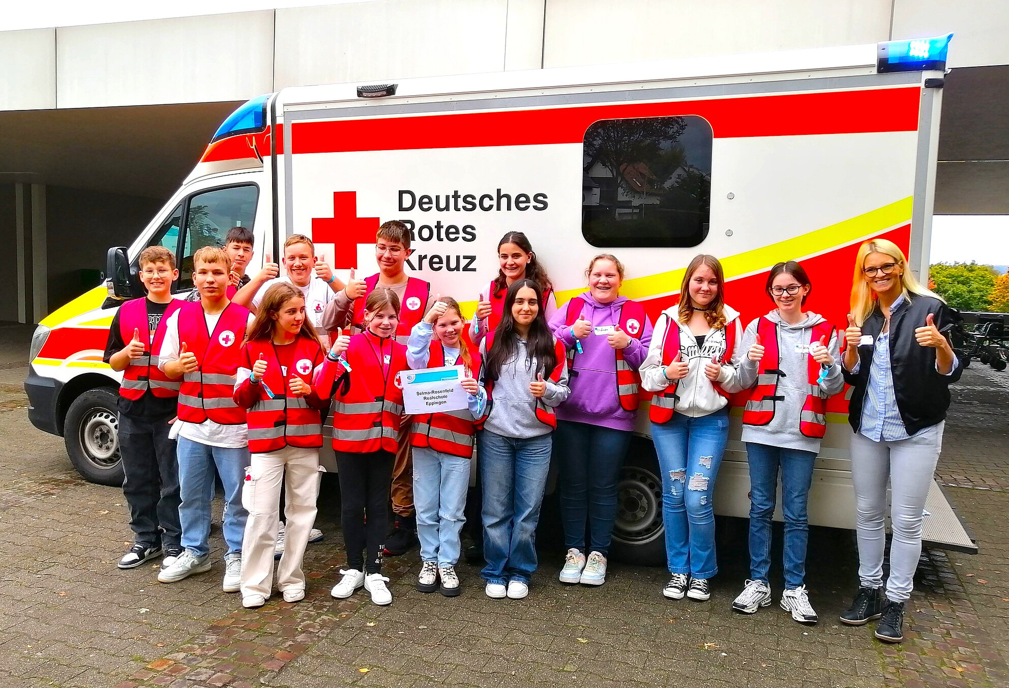 Bild von Schülerexkursionsgruppe vor dem Rettungswagen